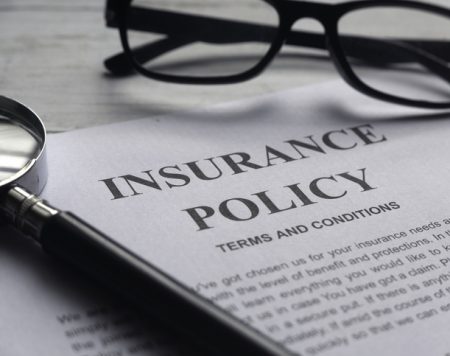 Selective focus of magnifying glass,glasses and Insurance Policy letter on a white wooden background. Selective focus of magnifying glass,glasses and Insurance Policy letter on a white wooden background.
